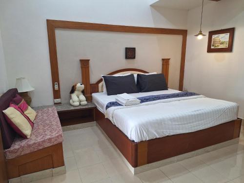 a bedroom with a large bed and a stuffed animal at Rosie Garden & Home in Na Jomtien