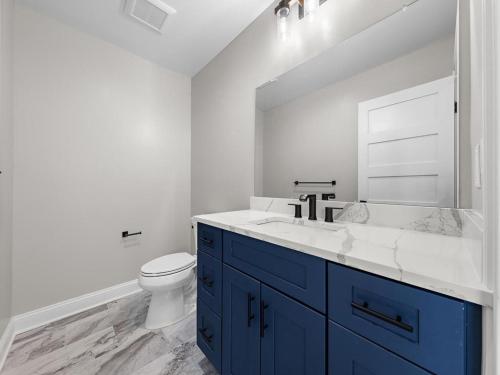 a bathroom with a sink and a toilet and a mirror at Stunning Ocean Block W-A Pool, New Construction! in Ship Bottom