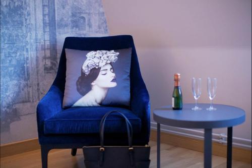 a blue chair with a pillow of a woman with a tiara at Scandic Winn in Karlstad