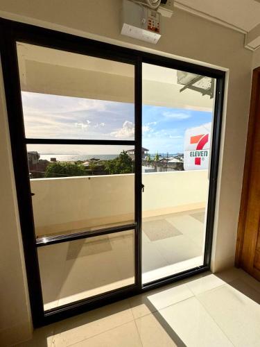 a sliding glass door with a view of a balcony at 24-Seven Guesthouse - Room 204 in Catbalogan