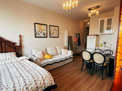 a bedroom with a bed and a table and chairs at Beijing city center - Cosy family suite with city view in Beijing