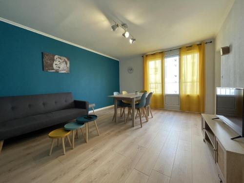 un salon avec un canapé, une table et des chaises dans l'établissement Le Savanah - Spacieux - 6p - Rêve au Mans, au Mans