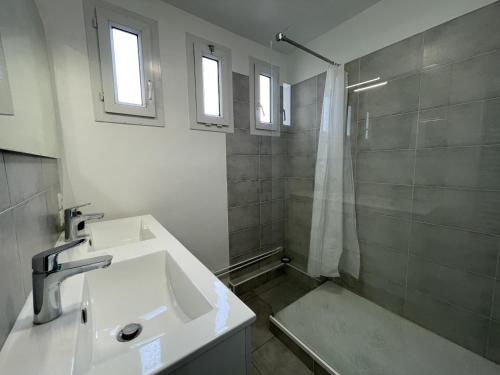 une salle de bain blanche avec un lavabo et une douche dans l'établissement Le Savanah - Spacieux - 6p - Rêve au Mans, au Mans