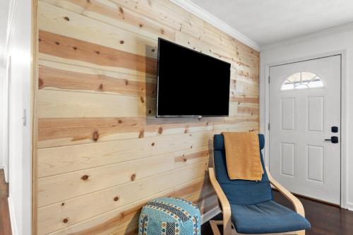 a living room with wooden walls and a flat screen tv at Grey Duck in Beattyville