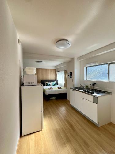 a kitchen with a sink and a bed in a room at nestay apartment tokyo kagurazaka in Tokyo