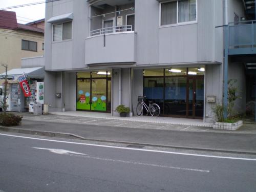 a building with a bike parked in front of it at ホテルクニミ鴨宮 in Odawara