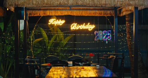 a table in a restaurant with neon signs on the wall at TK Coconut Camping in Tanjung Karang