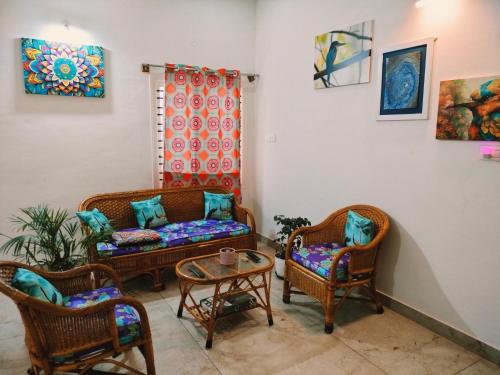 a living room with wicker chairs and a couch at Just for women homestays in Chikmagalūr