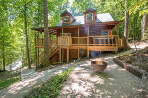 a log cabin in the woods with a large deck at Climb On in Rogers