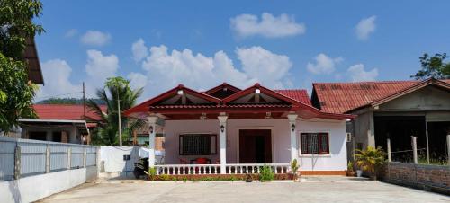 una pequeña casa con techo rojo en 老挝智尊酒店Laos Supre Hotel, en Luang Prabang