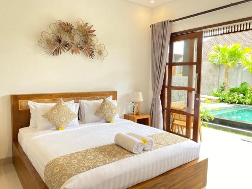 a bedroom with a bed and a swimming pool at Kubera Villa Kemenuh by Prasi in Ubud