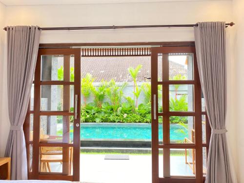 an open door to a pool seen from a room at Kubera Villa Kemenuh by Prasi in Ubud