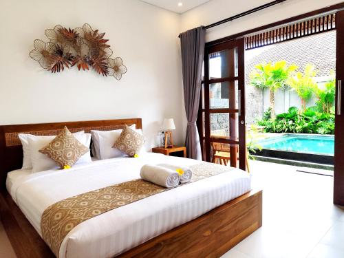 a bedroom with a bed and a swimming pool at Kubera Villa Kemenuh by Prasi in Ubud