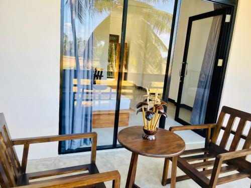 a table with a vase on it next to two chairs at Tranquil Sanctuary Yala in Tissamaharama