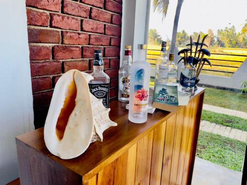 a table with a hot dog and bottles of alcohol at Tranquil Sanctuary Yala in Tissamaharama