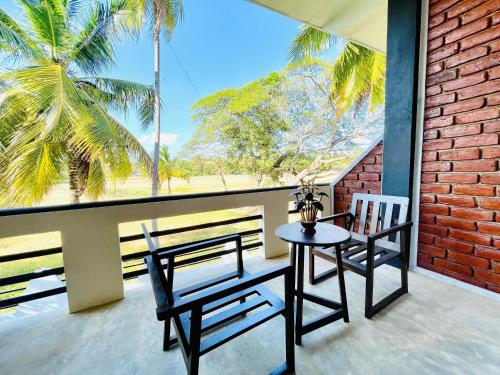a table and chairs on a balcony with a view of the ocean at Tranquil Sanctuary Yala in Tissamaharama