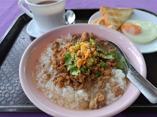 a plate of food with a bowl of rice with a spoon at Armthong Resort in Nakhon Nayok