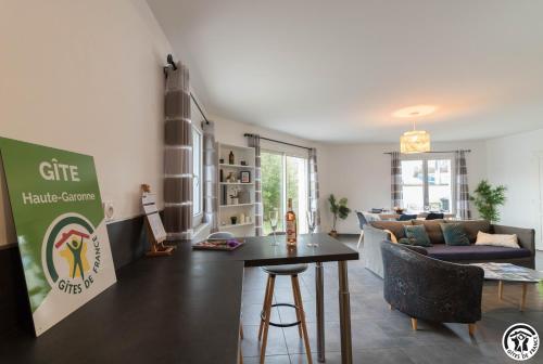 un salon avec une table et un canapé dans l'établissement Les Villas de Castel - Villa Les lauriers, à Castelmaurou