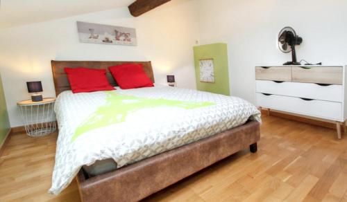a bedroom with a bed with red pillows and a dresser at Villa spacieuse à Divajeu avec piscine privée in Divajeu