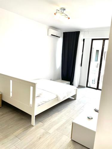 a bedroom with a white bed and a large window at Vitan Marvel in Bucharest