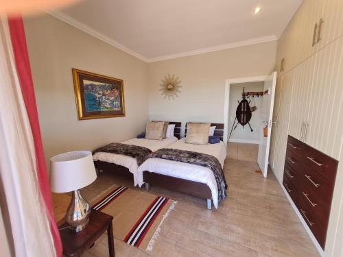 a bedroom with two beds and a lamp in it at 3onPacific in Sedgefield