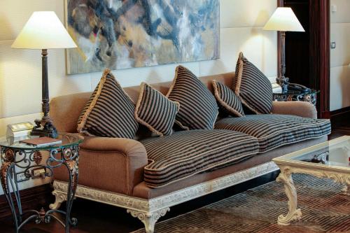 a brown couch with pillows in a living room at Anantara Palazzo Naiadi Rome Hotel - A Leading Hotel of the World in Rome
