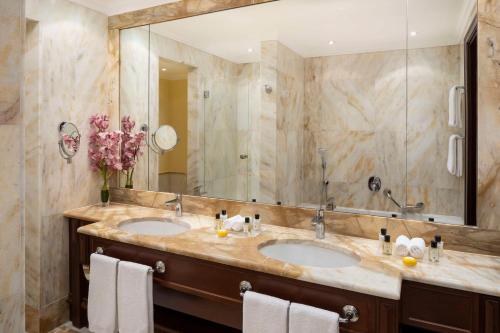 a bathroom with two sinks and a large mirror at Anantara Palazzo Naiadi Rome Hotel - A Leading Hotel of the World in Rome