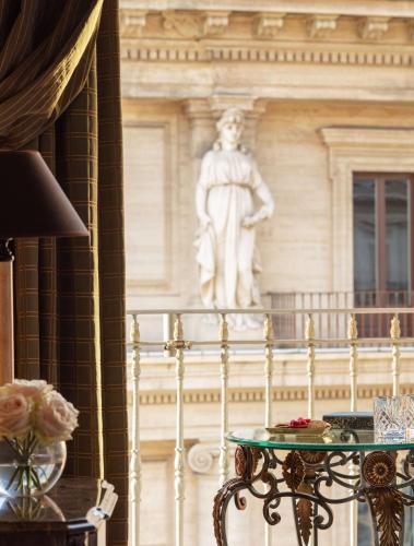 a statue on a building with a table in front of it at Anantara Palazzo Naiadi Rome Hotel - A Leading Hotel of the World in Rome