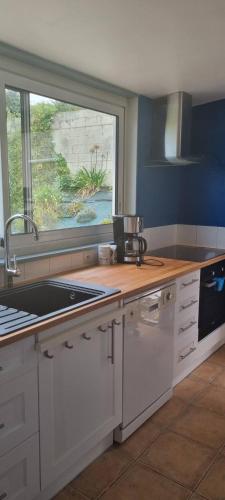 d'une cuisine avec un comptoir, un évier et une fenêtre. dans l'établissement Maison avec jardin à 1km de la plage du Val-André, à Pléneuf-Val-André