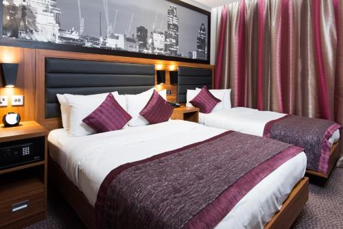 a hotel room with two beds and a wall with a picture at London Court Hotel in London