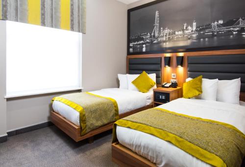 a hotel room with two beds and two lamps at London Court Hotel in London