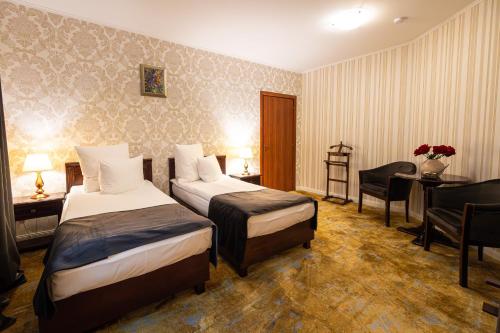 a hotel room with two beds and a desk at Hotel Brilliant Plaza in Zalău