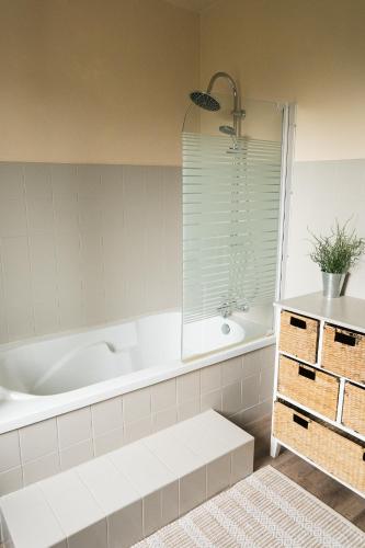 une salle de bain avec une baignoire et un lavabo dans l'établissement Kerlavost, à Trégastel