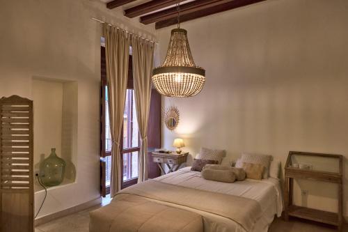 una camera da letto con un letto grande e un lampadario di Can Savella - Turismo de Interior a Palma de Mallorca