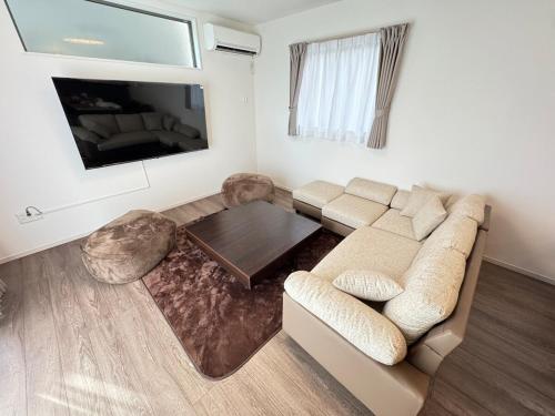 a living room with a couch and a coffee table at Ganadan太宰府 in Dazaifu