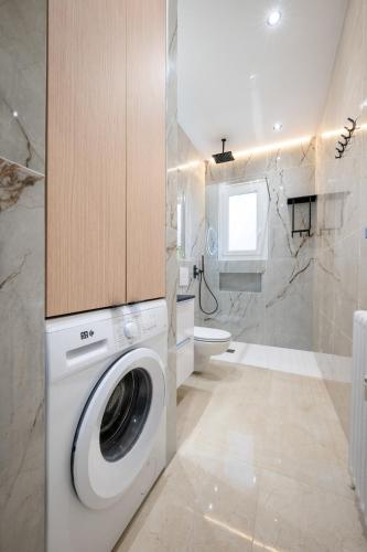 une salle de bain avec machine à laver et toilettes dans l'établissement Bleu Rivage - Magnifique 2P au Port de Nice - 1 chambre et 1 Mezzanine, à Nice