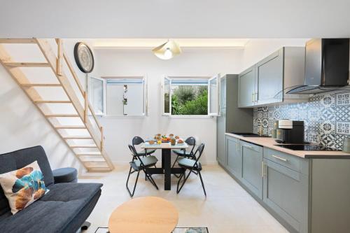 une cuisine et un salon avec une table et des chaises dans l'établissement Bleu Rivage - Magnifique 2P au Port de Nice - 1 chambre et 1 Mezzanine, à Nice