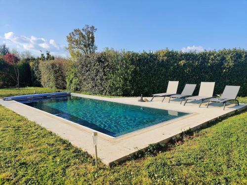 une piscine avec des chaises dans une cour dans l'établissement La Suite Niortaise, à La Crèche