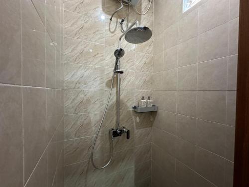 a shower with a shower head in a bathroom at Kubu Dimel Suites Home in Nusa Dua