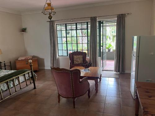 a living room with a couch a table and a chair at Rondebosch Gardens in Humansdorp