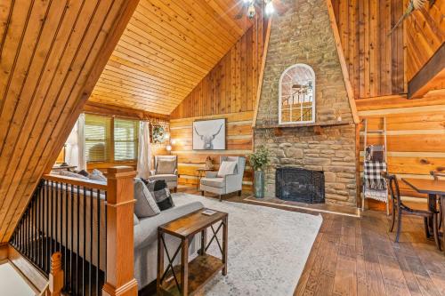 a living room with a stone fireplace in a log cabin at Soulshine in Beattyville