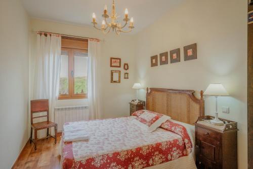 a bedroom with a bed and a chandelier at La Cardeñuela in Burgos