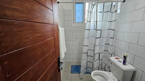 a bathroom with a toilet and a shower curtain at Tulip Serenity in Malindi