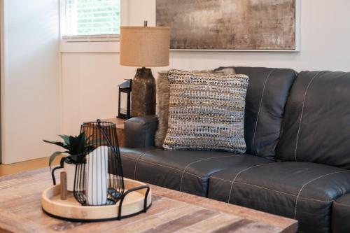 a living room with a leather couch and a table at 50 Shades of Slade in Rogers