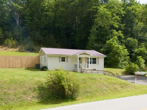 a small house on top of a grassy hill at 50 Shades of Slade in Rogers
