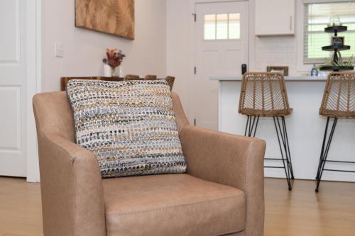 a chair in a living room with a pillow on it at 50 Shades of Slade in Rogers