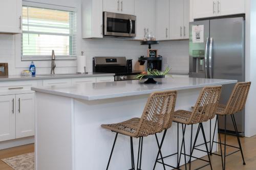 a kitchen with white cabinets and a counter with stools at 50 Shades of Slade in Rogers