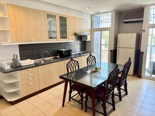 a kitchen with a table and chairs and a refrigerator at Samsen Suites Spacious 2BR Contemporary Thai Style in Bangkok
