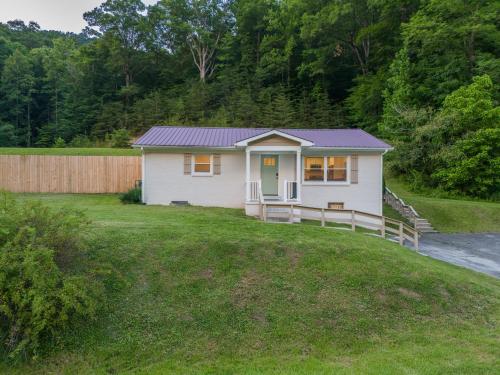 a small white house in a yard with a fence at 50 Shades of Slade in Rogers