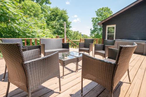 a deck with wicker chairs and a glass table at Huckleberry Arch in Rogers